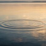 Calm water surface with a single gentle ripple — imagery for relaxation and stress relief