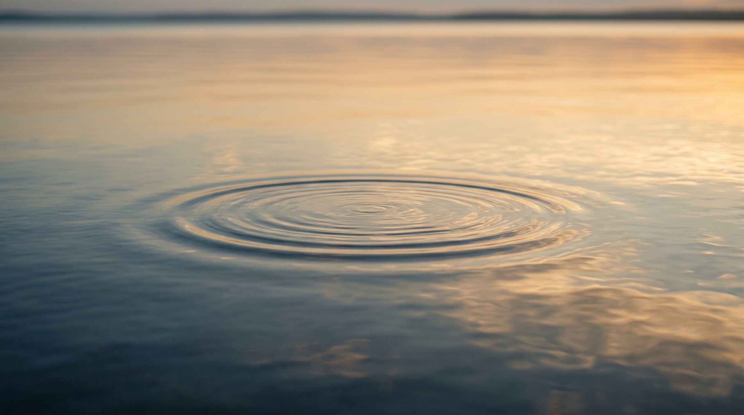 Calm water surface with a single gentle ripple — imagery for relaxation and stress relief