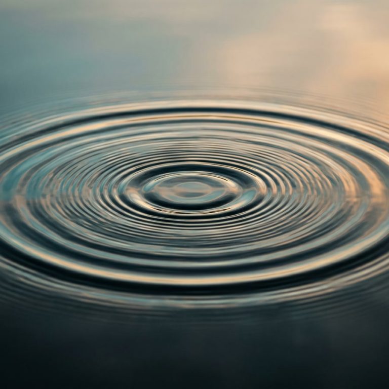 Concentric ripples spreading across calm water, illustrating how vibration therapy travels through the body for back pain relief